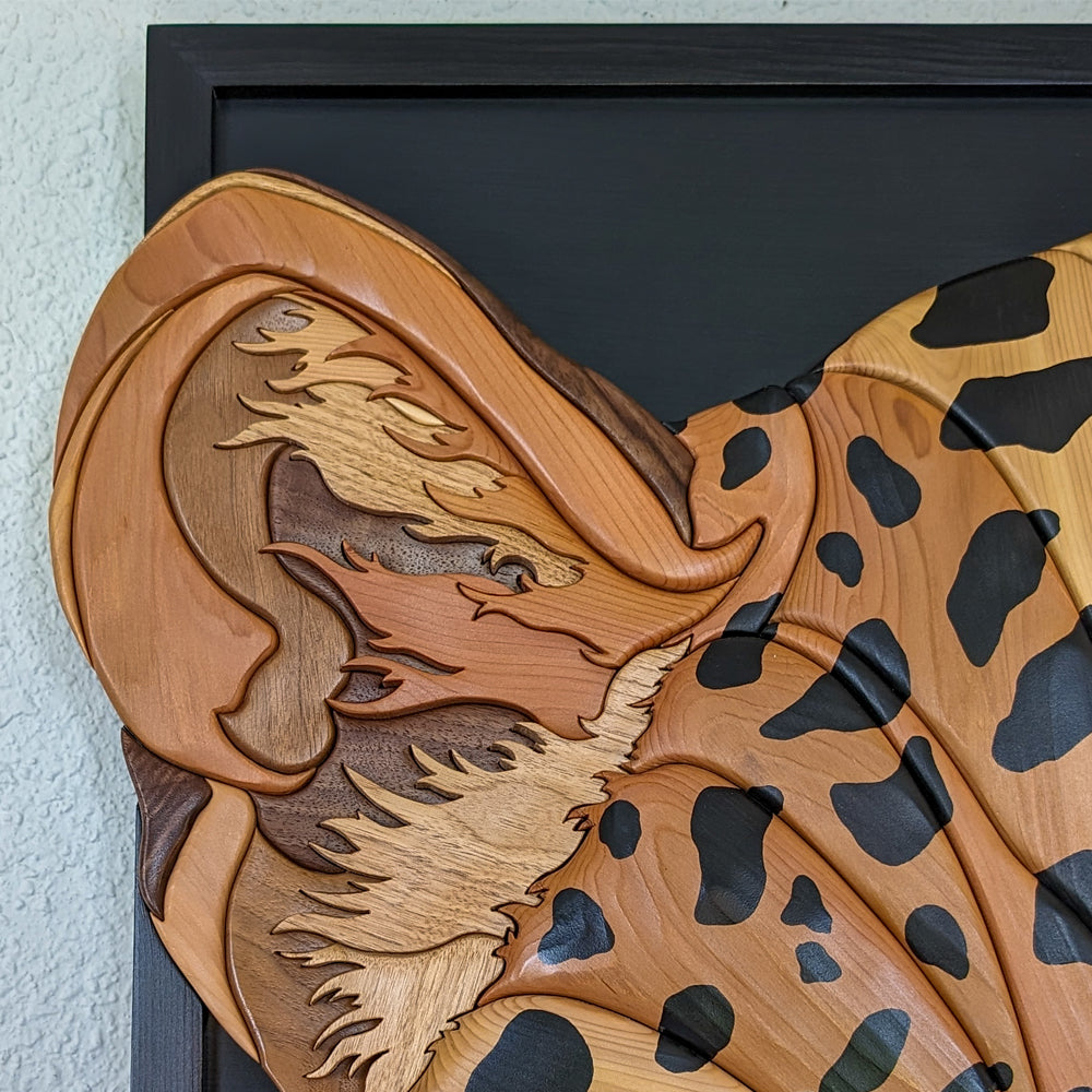 Close-up of carved details on jaguar wood sculpture by Alex Jepson, highlighting expert wood carving craftsmanship.
