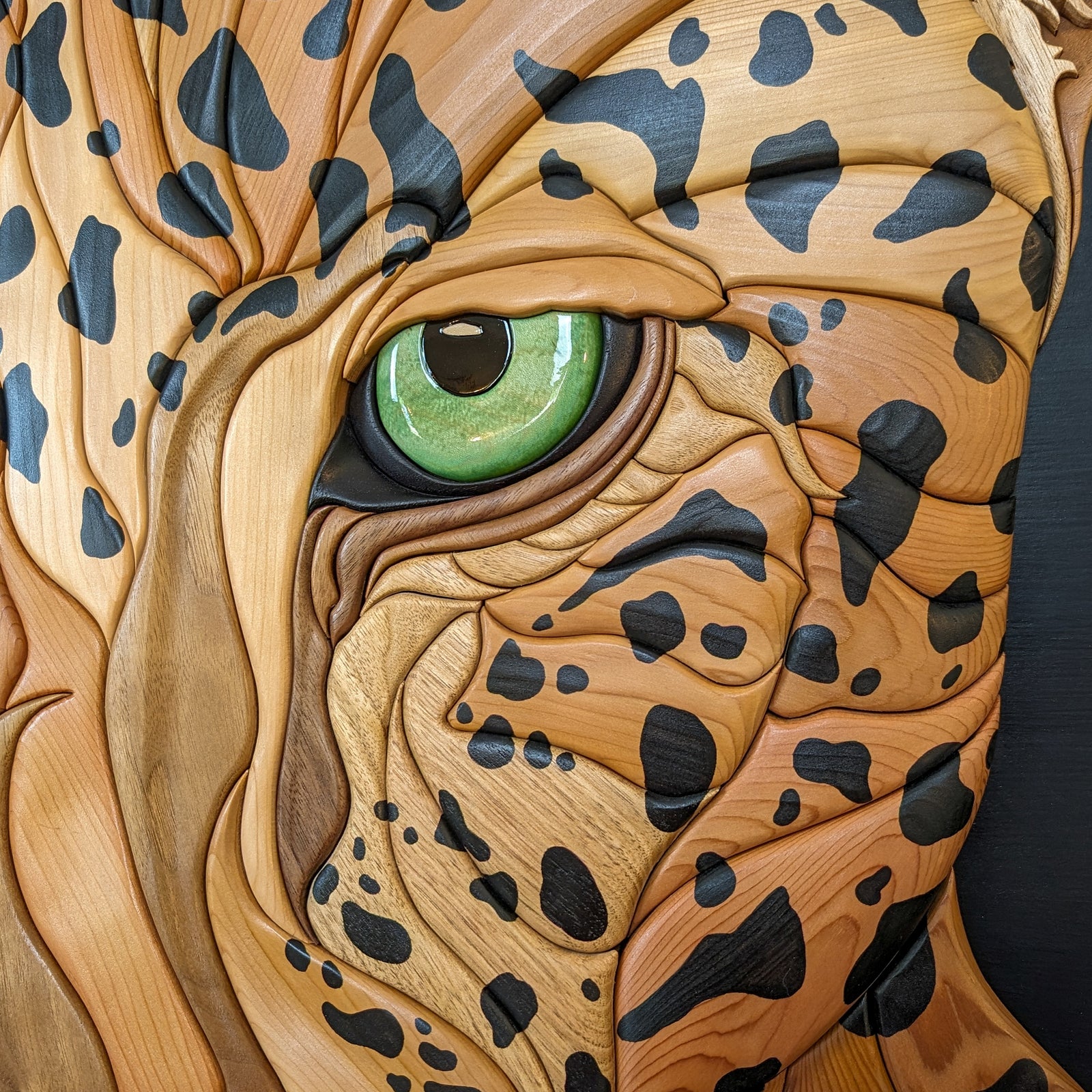 Close-up details of the jaguar wood sculpture by Alex Jepson, highlighting intricate carving techniques and the natural beauty of the wood grain.